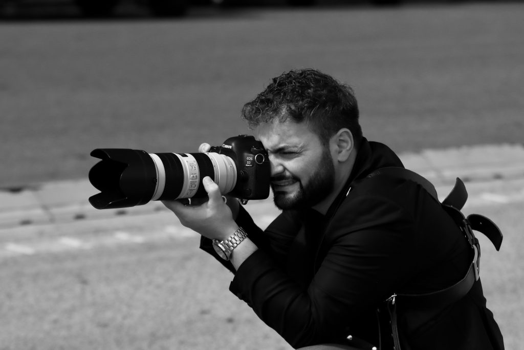 Black and white image of a photographer capturing a scene in Naples, Italy