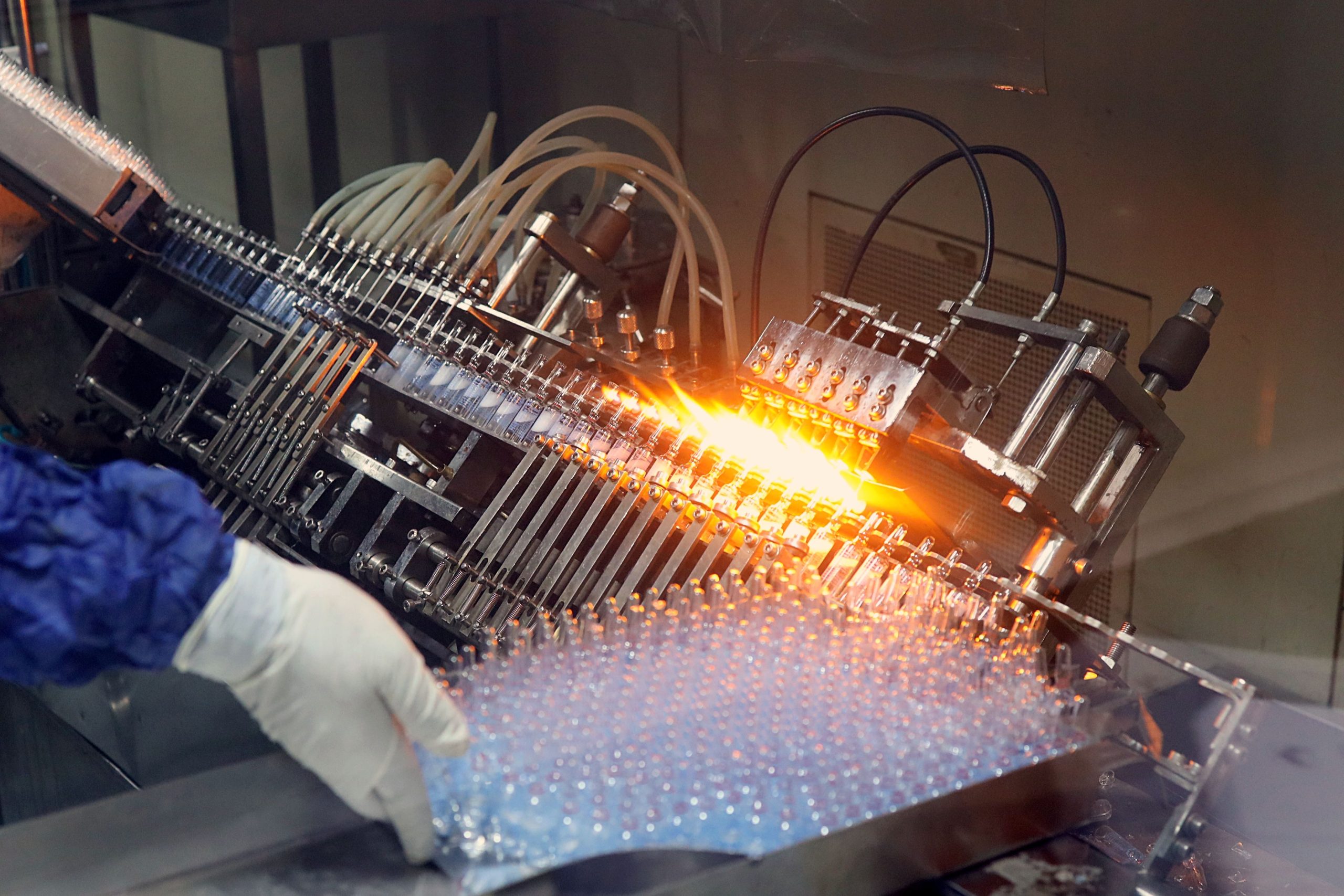 Glass ampoules pass through pharmaceutical filling and sealing machinery